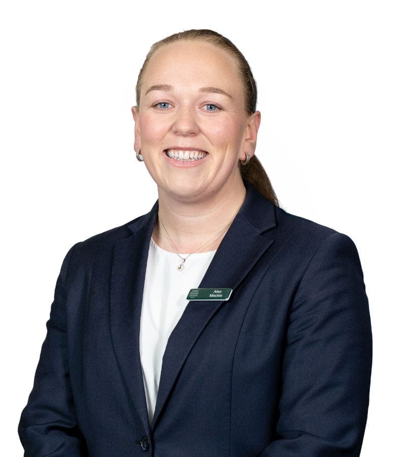 Professional woman in navy blazer smiling at camera