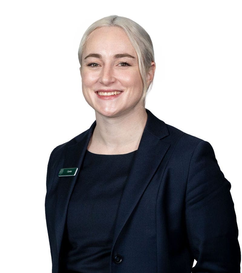 Professional woman smiling in navy blazer with name badge