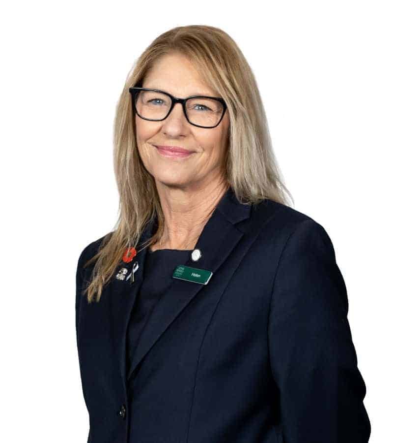 Professional woman in navy blazer with glasses smiling
